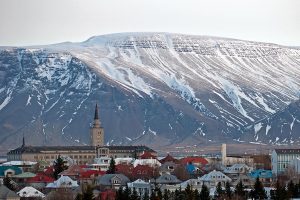 A view of Reykjavik Iceland with a looming snow-capped mountain behind it