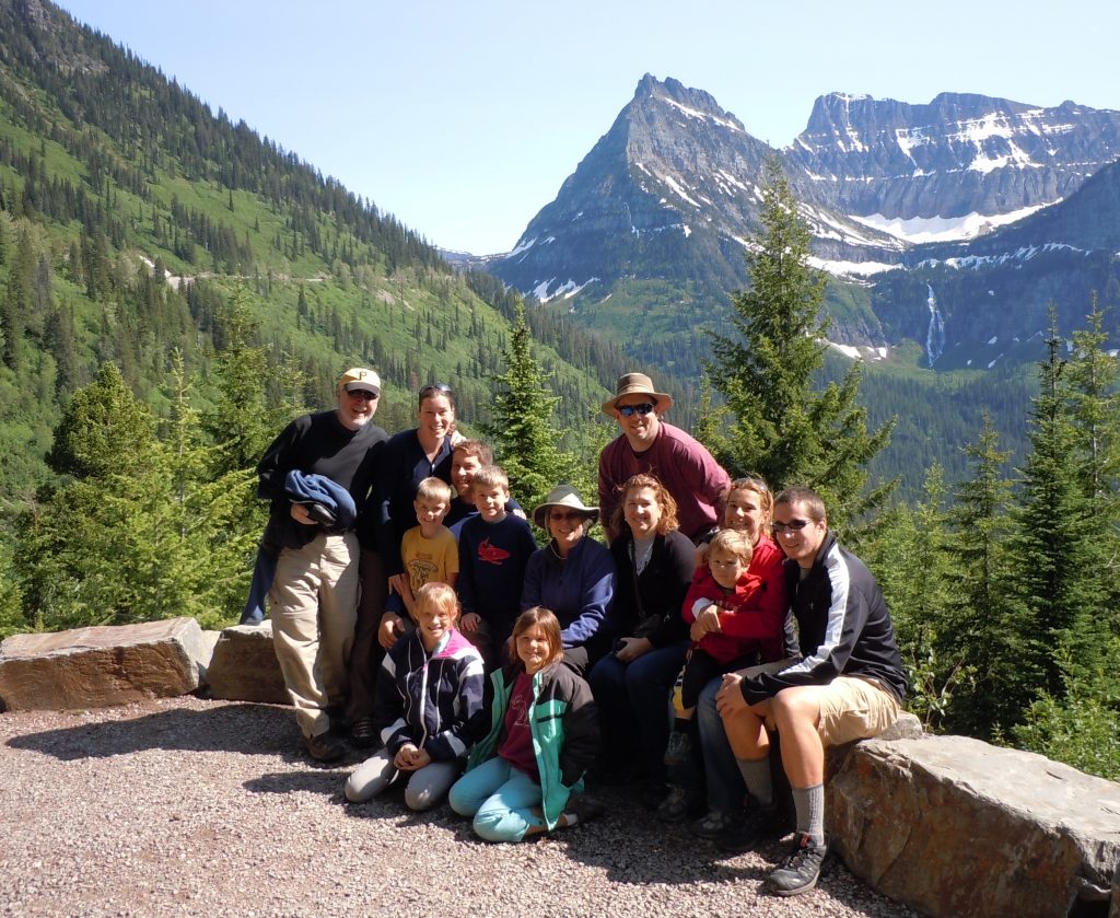 a large family photo in front of the rocky mountains