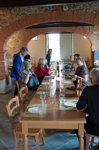 dining at a long table under stone arches in Florence