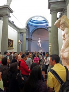 a crowd looking at the David in Florence