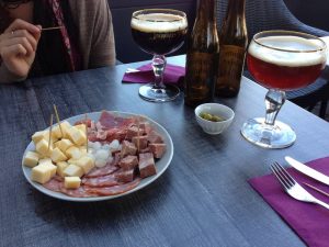 a plate of meats and cheeses and beer in Belgium
