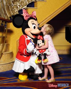 a young child gives Minnie Mouse character a kiss on a Disney Cruise