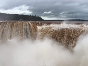 the huge rush of brown water over Iguazu waterfalls in Argentina