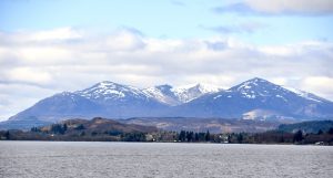 lake with snow-capped mountains in the distance of Loch Ness in Scotland