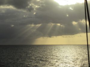 rays of light spilling through rain clouds over the ocean in Grenada