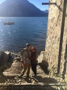 couple standing by the water at the bottom of cobblestone steps in varenna-lake-como