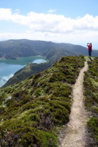 a dirt hiking trail overlooking an incredibly blue lake in the Azores. 