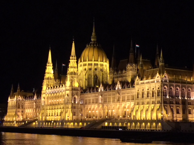 The Budapest parliment building lit up at night from the view of the river cruise
