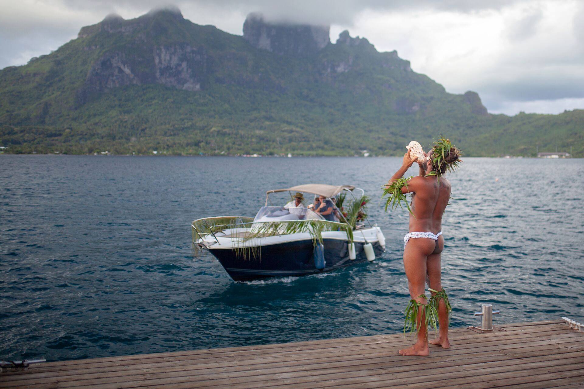 man blowing conch shell in welcome to Tahiti
