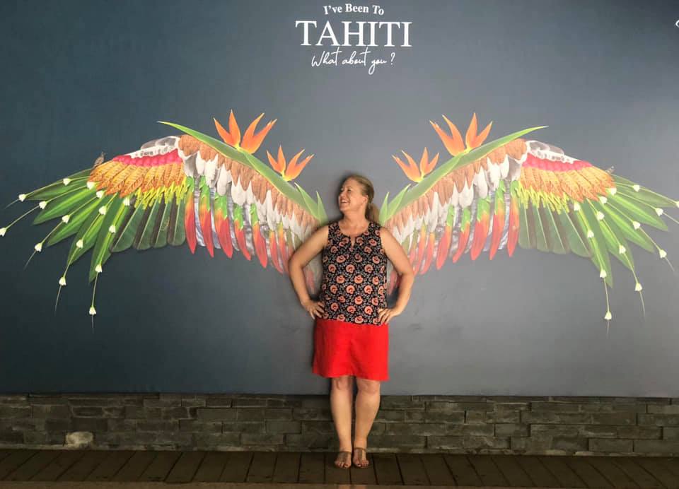 woman standing against painted wings Tahiti