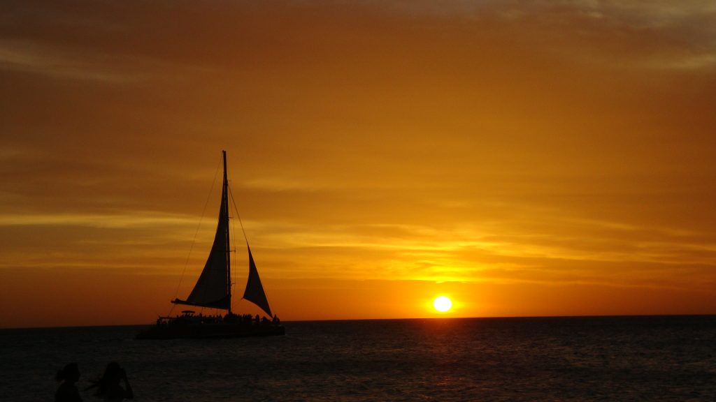 ocean sunset with sailboat in Aruba