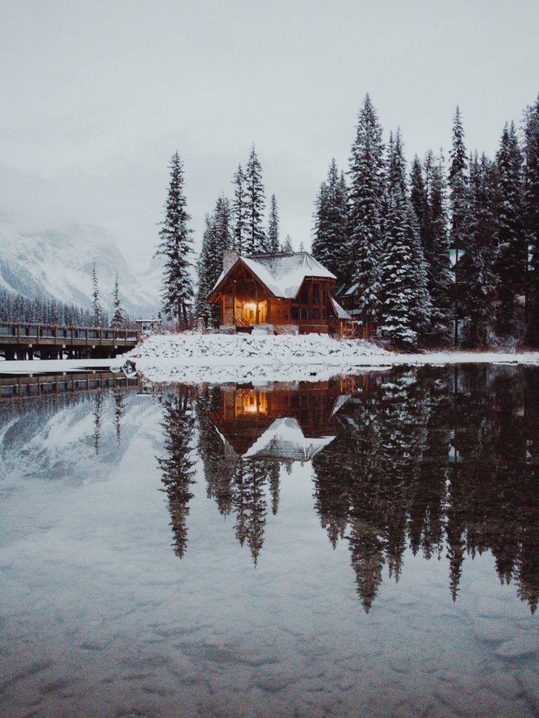 a cabin in a snowy landscape across emerald lake, Canada