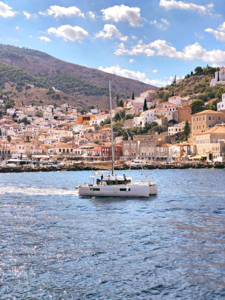 a catamaran in the bay of a village of Hydra built into the mountain in Greece