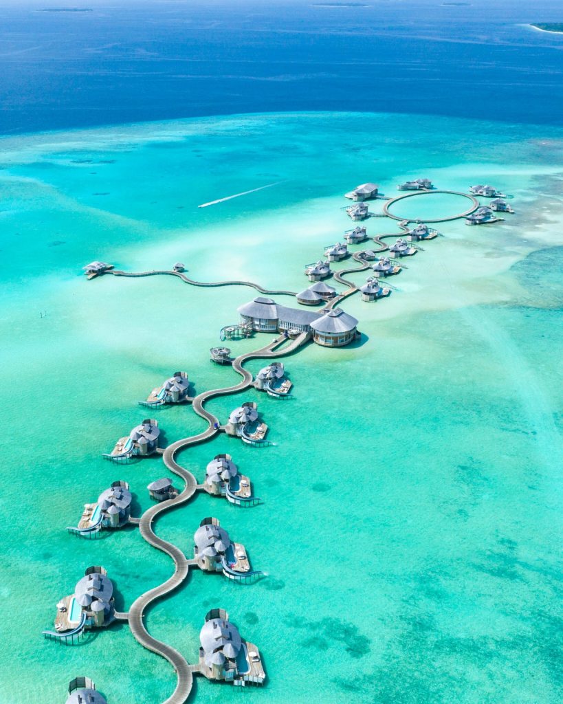 aerial shot of overwater villas with waterslides in the Maldives