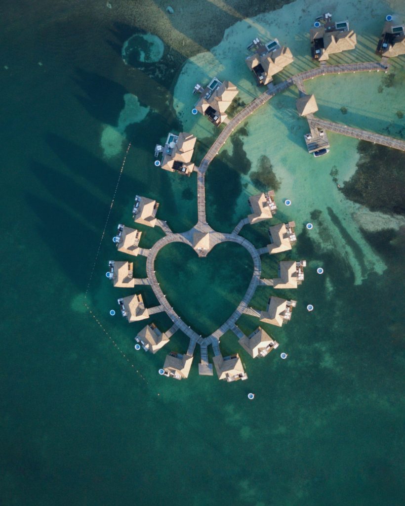 aerial shot of overwater bungalows with a heart shaped walkway in Jamaica