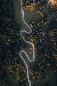looking down on a winding road surrounded by trees