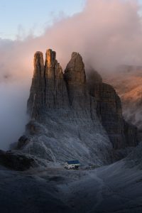 an imposing spire mountain towers above a small local Inn in the Dolomites Italy