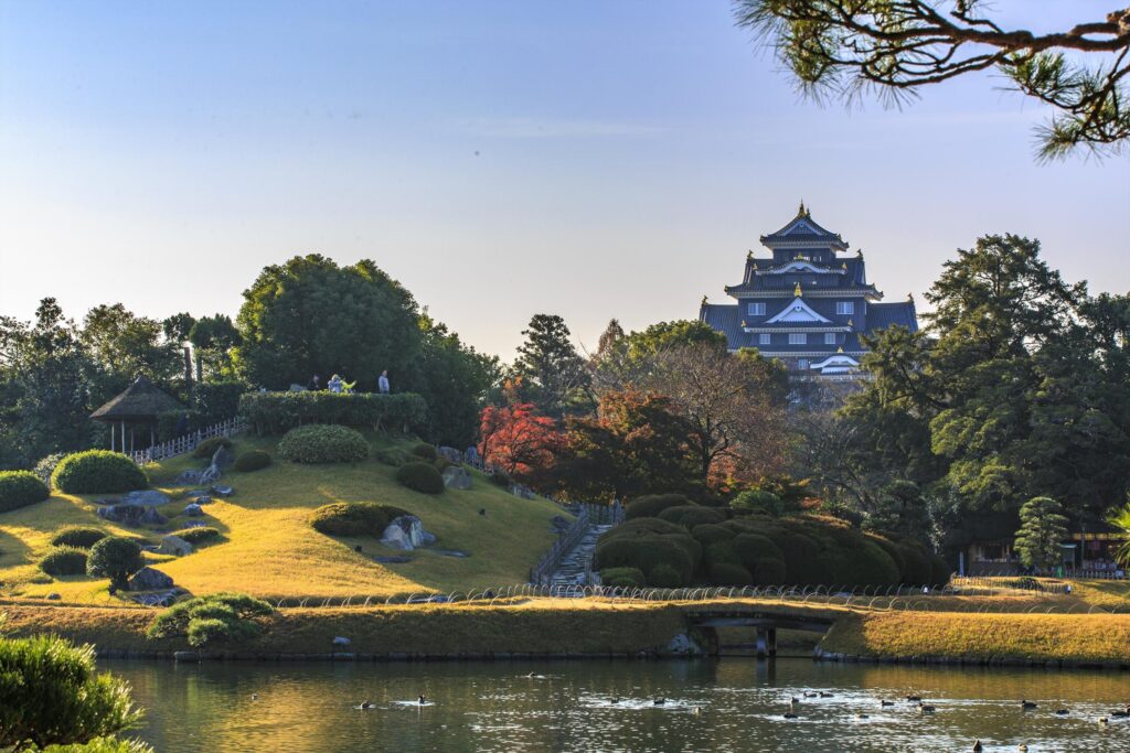 a japanese garden with lake and castle in background in Setouchi Japan
