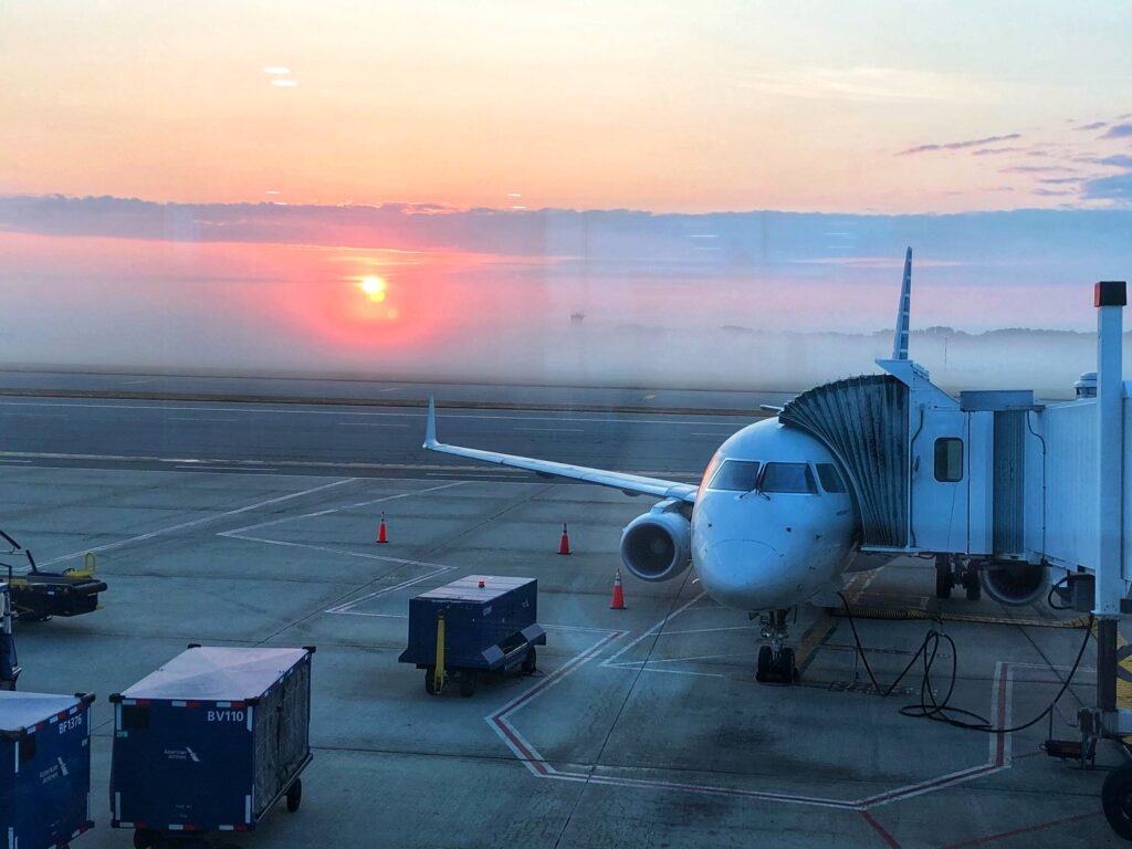 A plane on the tarmac and a stunning sunset behind