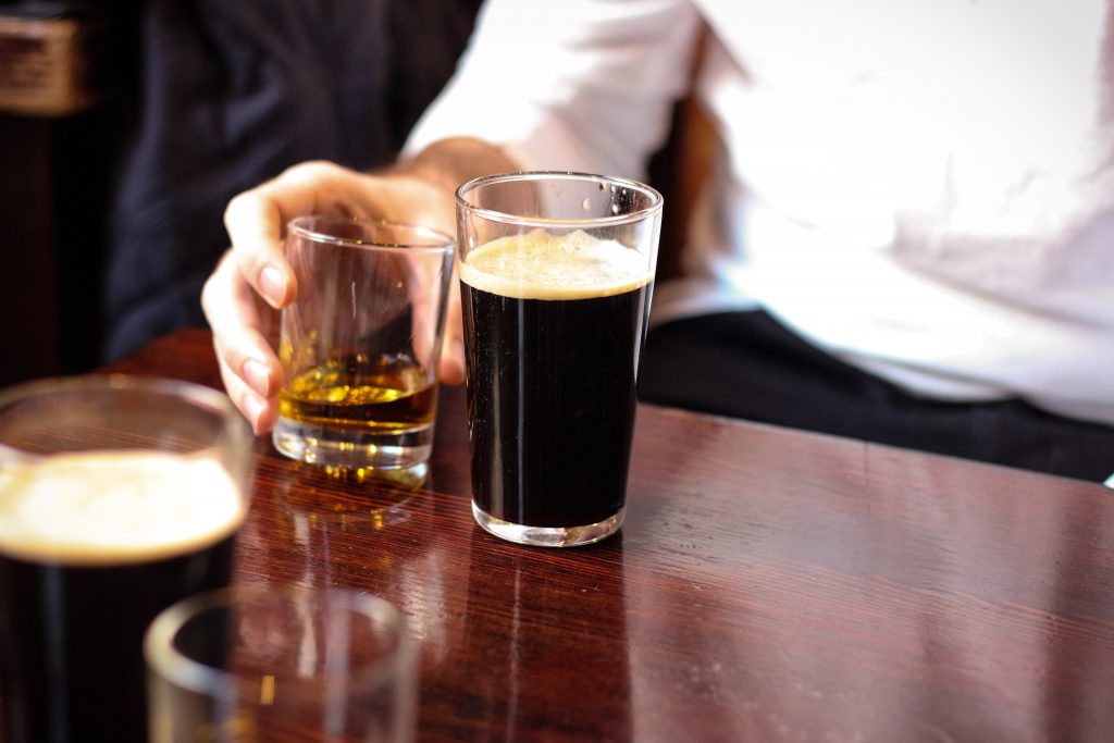 a dark pint of beer and a dram of Whisky