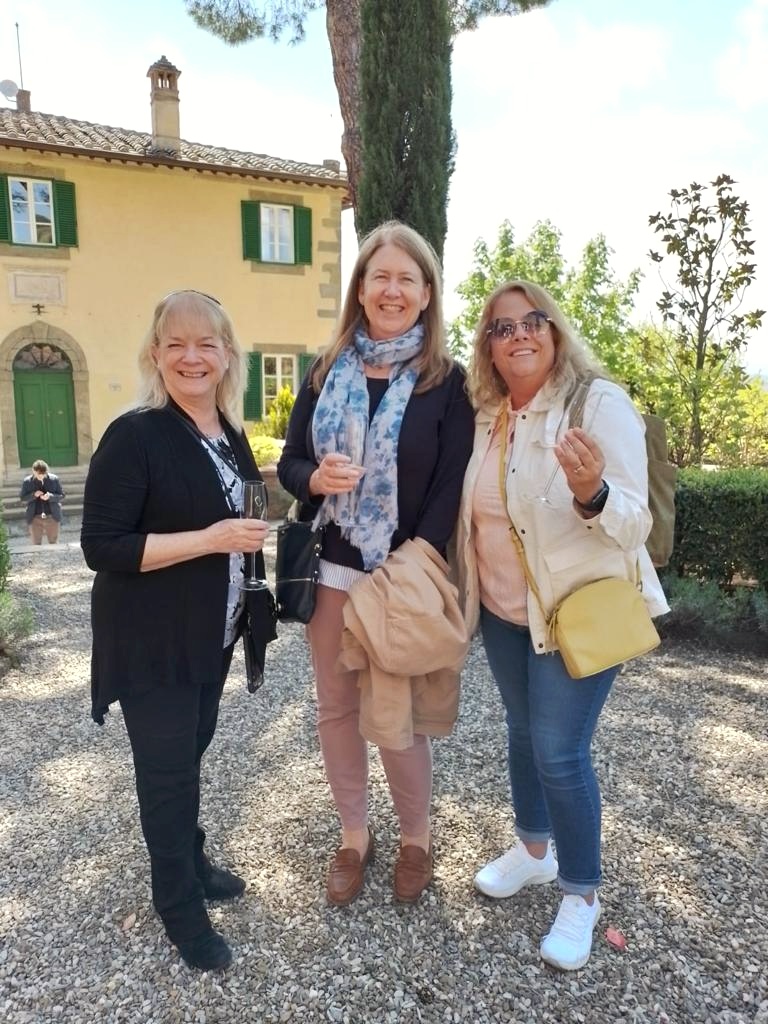three women ( Ann and Kristy) toast white wine in front of Villa Laura in Tuscany