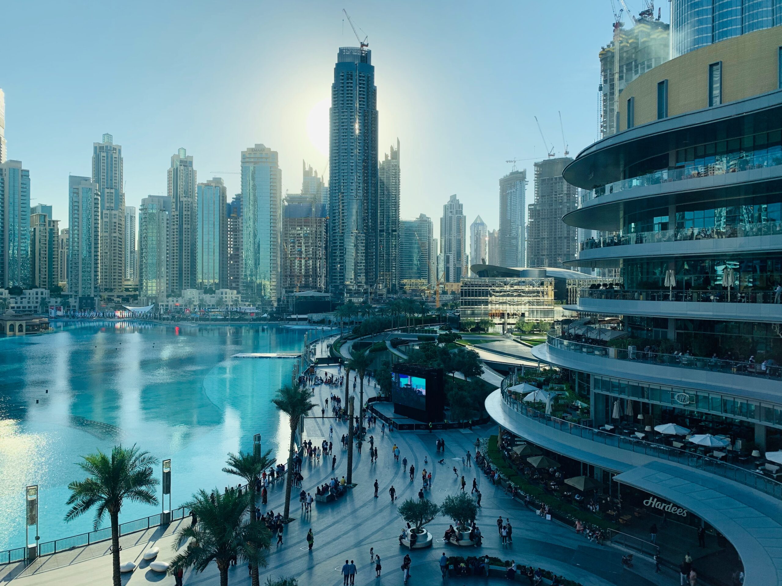 pedestrian boardwalk with large pool to one sideand glisteing skyskrapers behind in Downtown Dubai