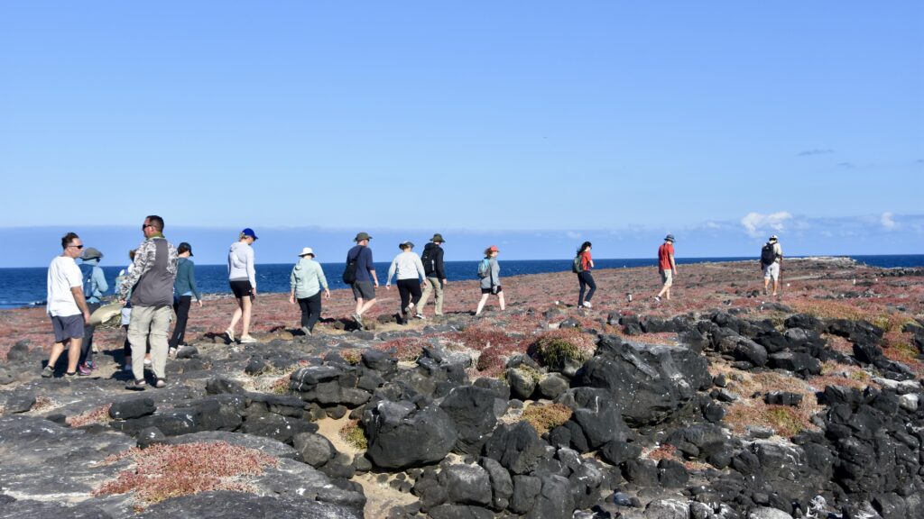 The Galapagos group on a hike through volcanic rock and low desert bush