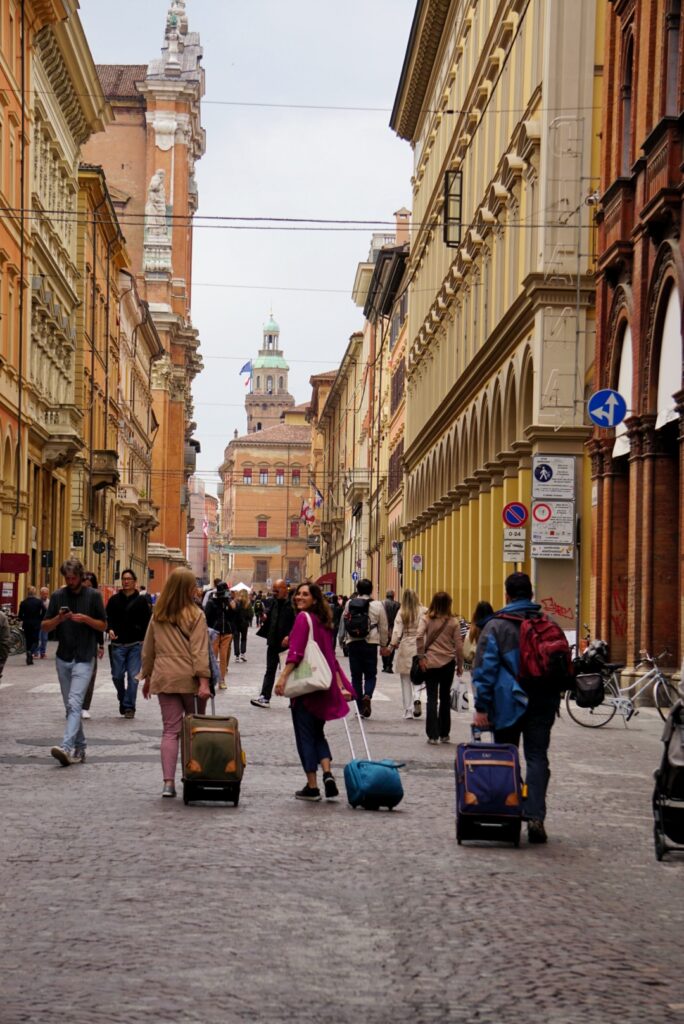 people walking down the cobblestone streets of Bologna