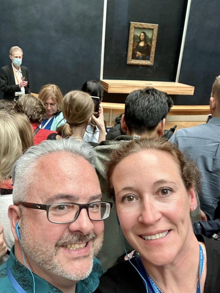 a couple celebrating their anniversary with the Mona Lisa in Paris