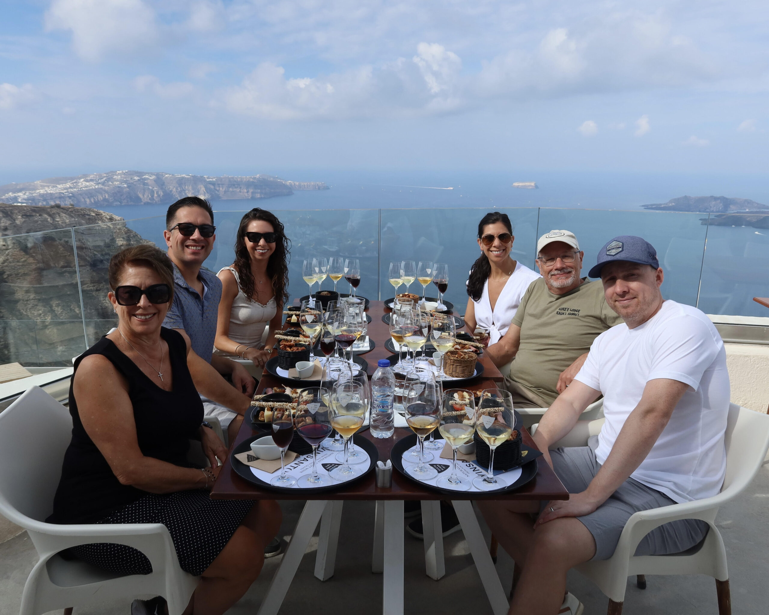 A family at a wine tasting table with views overlooking the sea in Santorini Greece