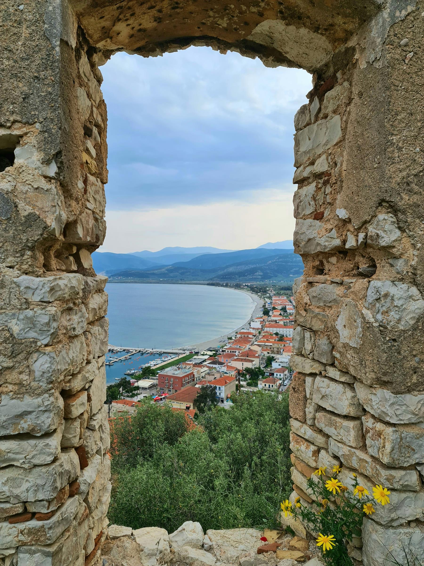 the view through an old stone window of the city of Npflaio on Mainland Greece and the bay.